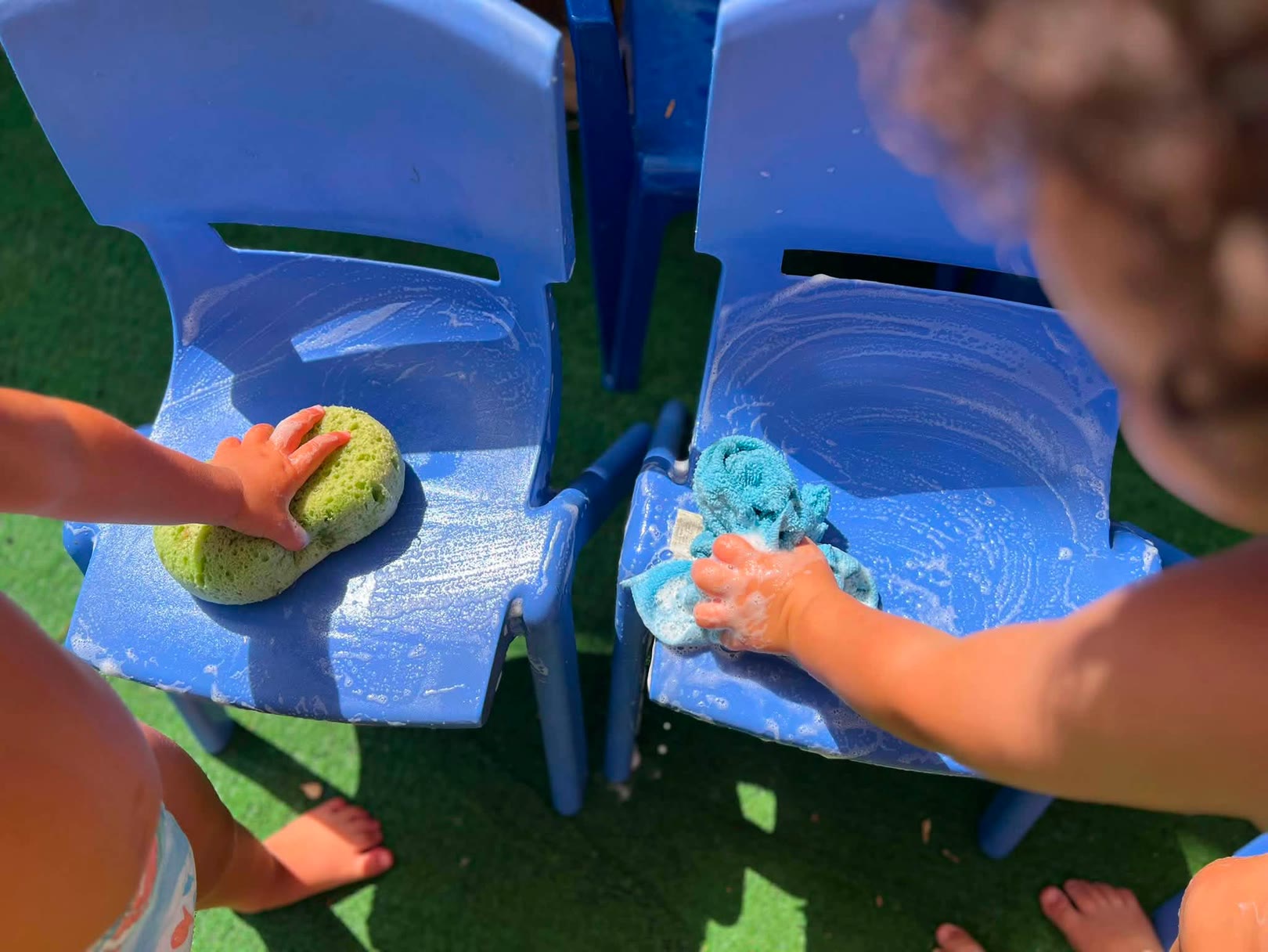 Due bambini stanno pulendo sedie blu con spugna e asciugamano