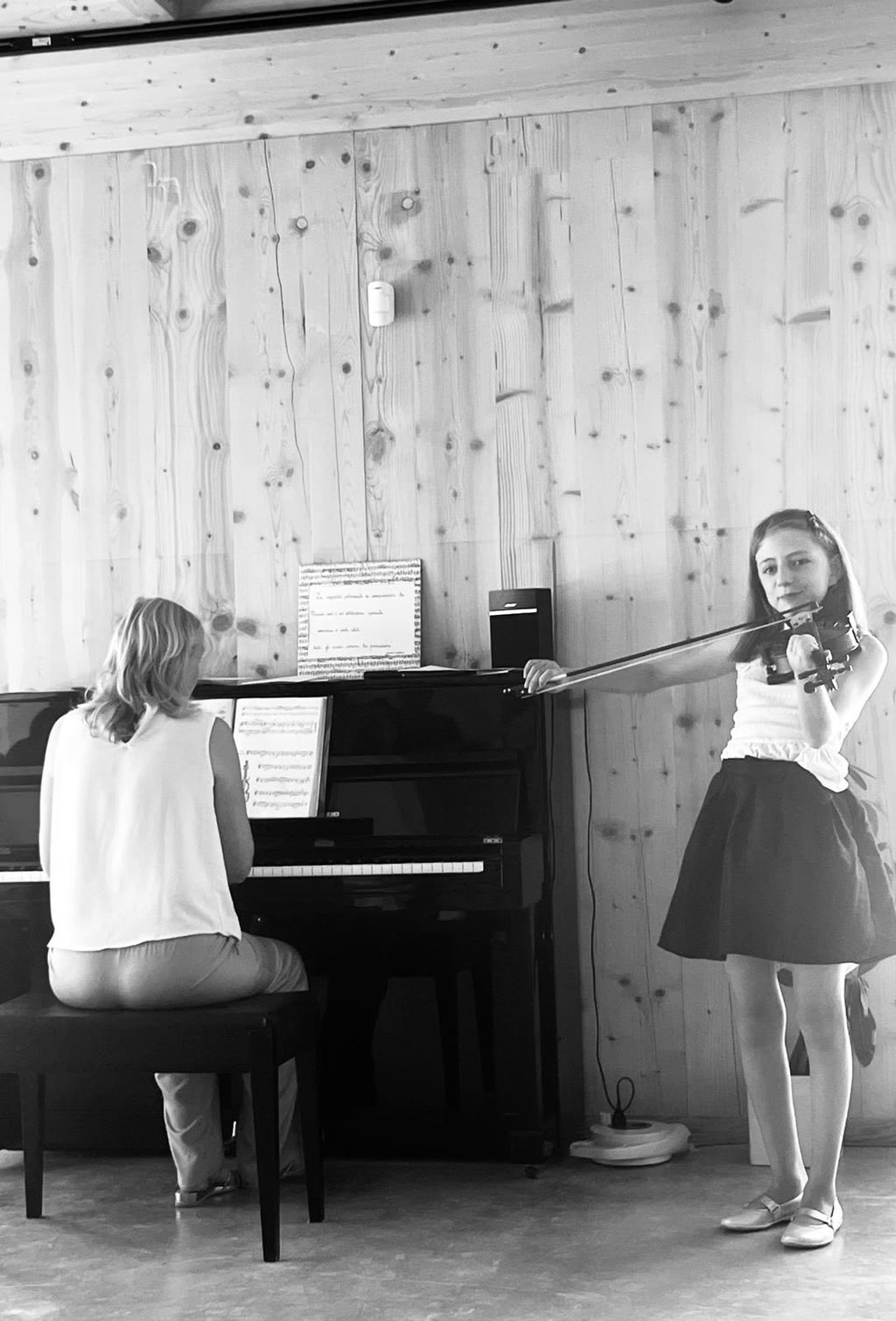 Una ragazza suona il violino mentre una donna suona il pianoforte