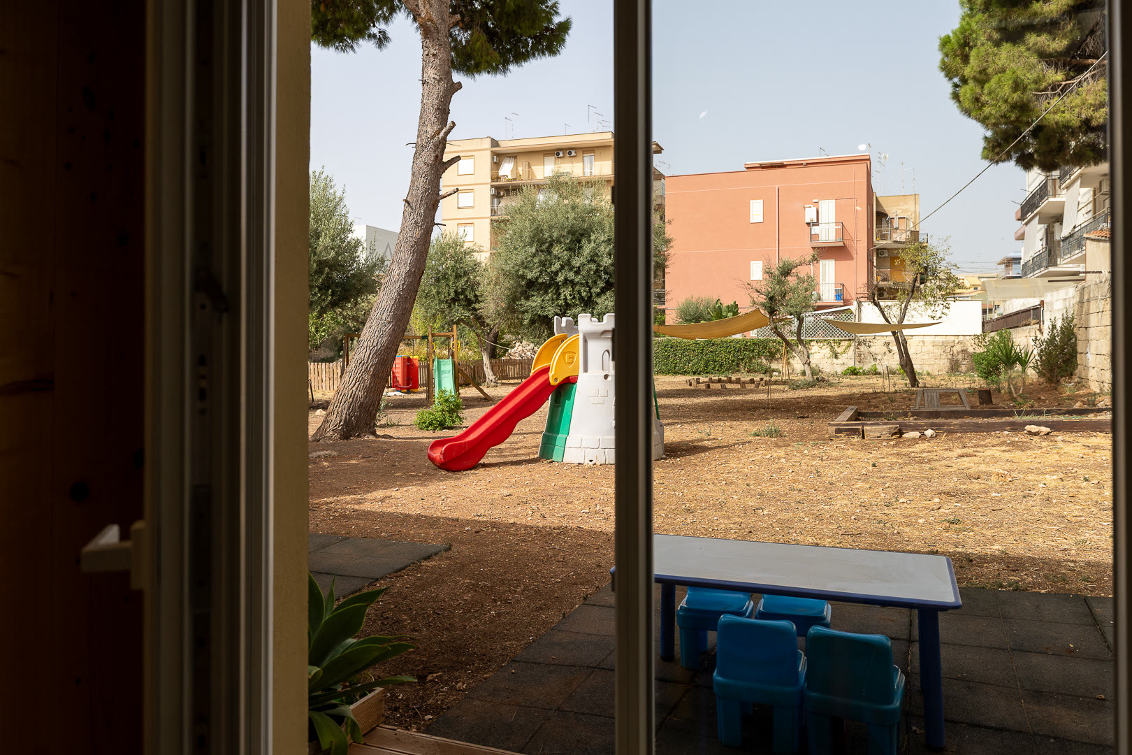 Il cortile con lo scivolo e la pedana, visto dalla soglia di un'aula.