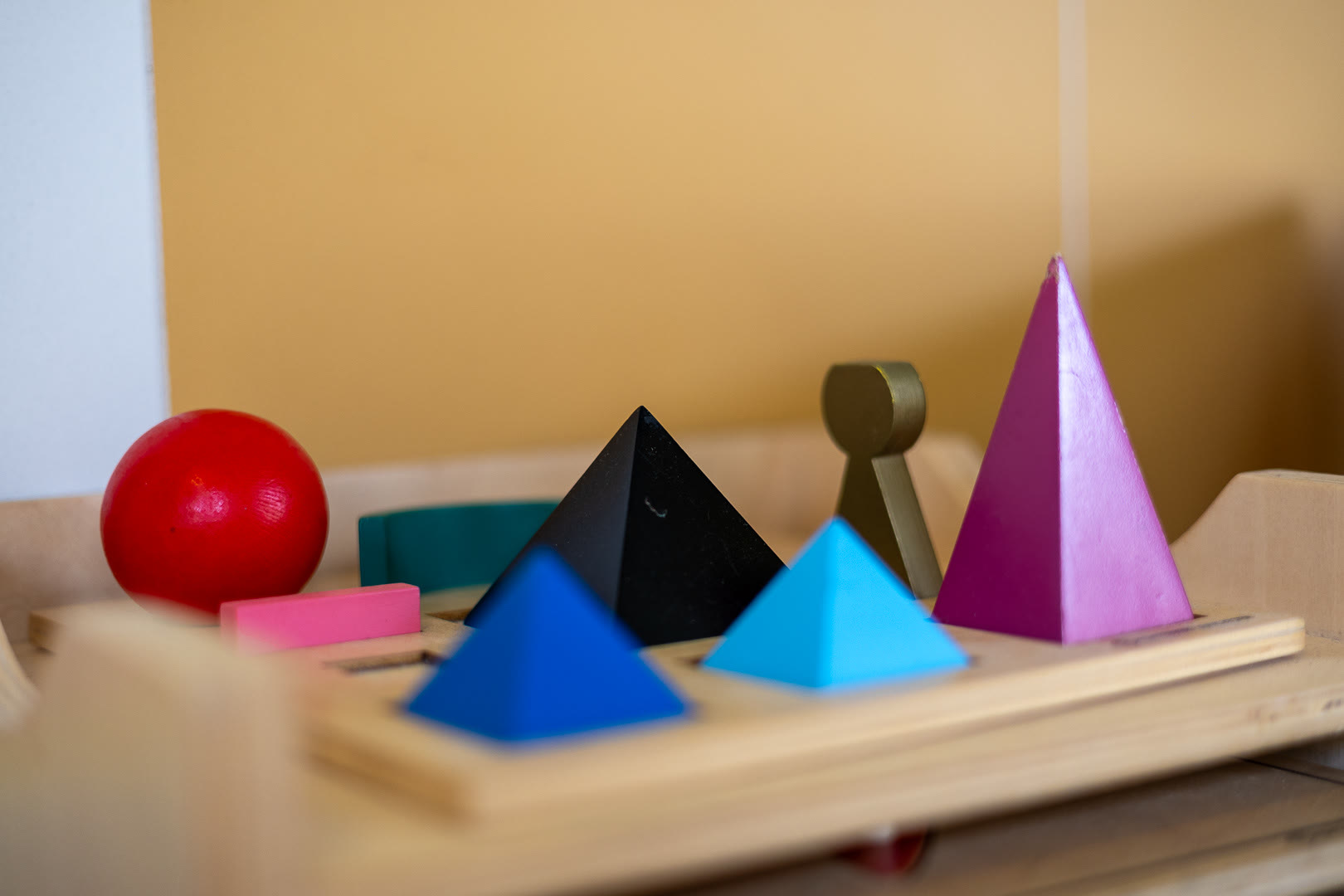 I solidi geometrici Montessori: sfera, piramidi, coni e cubi colorati.