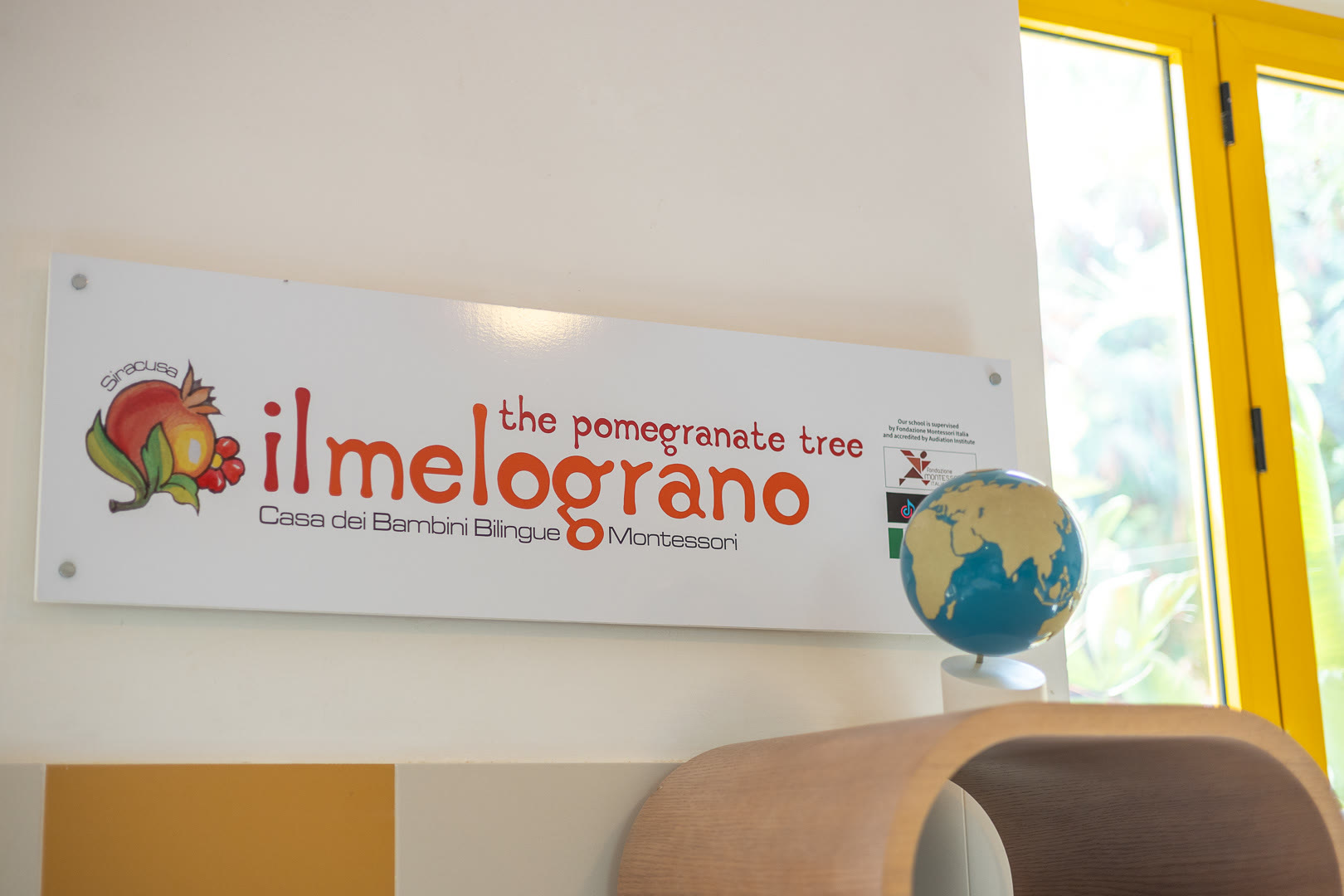 Insegna del Melograno con il disegno del frutto e la scritta Casa dei Bambini.